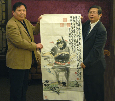 胡兴超向高雄市总干事葛龙军赠送陈光林钟馗画